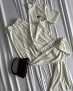 Unesi dozu elegancije u svoj svakodnevni stil uz ovaj ženski set u klasičnoj beloj boji. Ovaj komplet, koji čine udobna majica i široke pantalone, pruža savršen spoj minimalizma i sofisticiranosti. Lagan i prozračan materijal čini ga idealnim za toplije dane, dok bela boja daje čist i luksuzan izgled. Savršen je za casual varijante, putovanja ili urbani chic stil.

✔ Lagan i prozračan materijal
✔ Minimalistički i elegantan dizajn
✔ Klasična bela boja koja se lako kombinuje
✔ Idealan za dnevne i elegantne ou