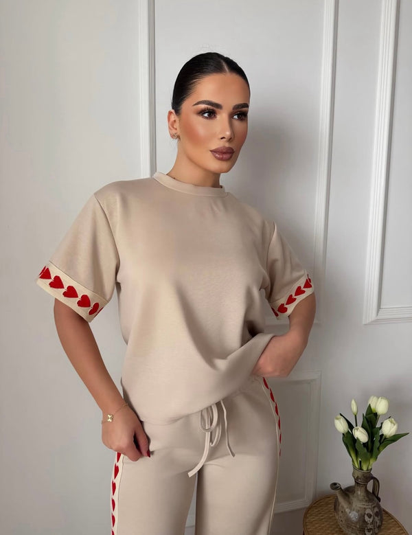 Savršen spoj udobnosti i trendi dizajna – ovaj ženski komplet sa srcima je idealan izbor za svakodnevni outfit. Majica jednostavnog kroja u kombinaciji sa pantalonama koje imaju upečatljiv detalj srca daje moderan i razigran izgled. Mekan i prijatan materijal omogućava maksimalnu udobnost, dok relaxed fit kroj pruža slobodu pokreta.

Ovaj komplet je savršen za opuštene dane, šetnje, putovanja ili casual kombinacije uz minimalan trud.